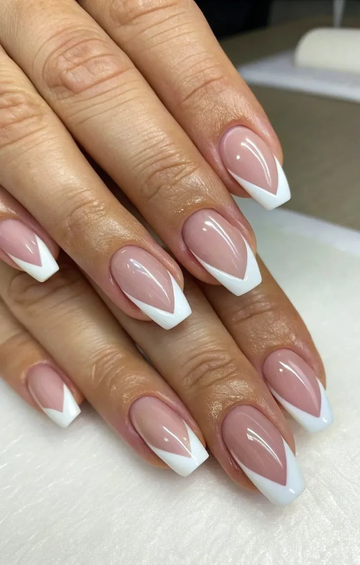 Almond nails featuring sharp white V-shaped French tips. Almond nails featuring sharp white V-shaped French tips.