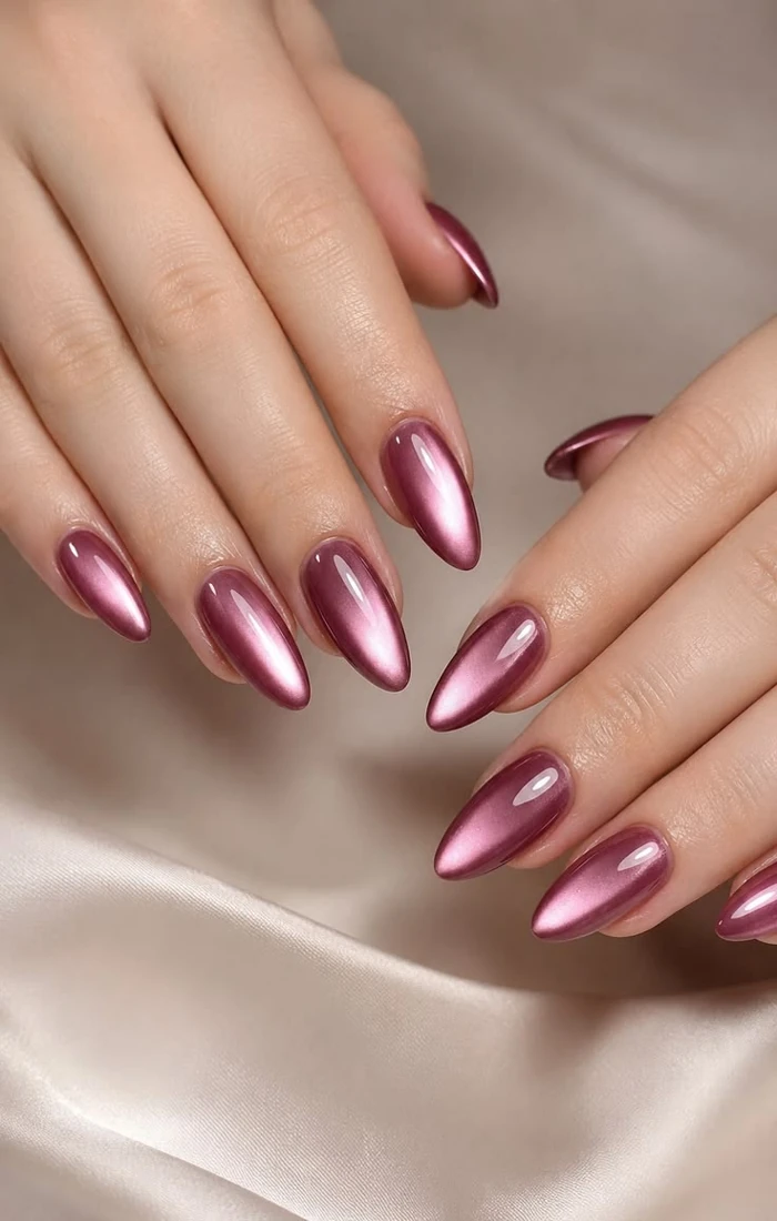 Almond-shaped burgundy cat eye nails with a bright central reflection. Almond-shaped burgundy cat eye nails with a bright central reflection.