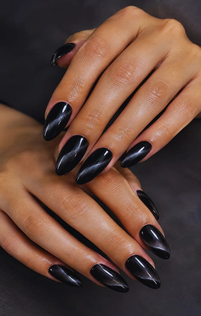 Black cat eye nails with smoky silver magnetic shimmer. Black cat eye nails with smoky silver magnetic shimmer.