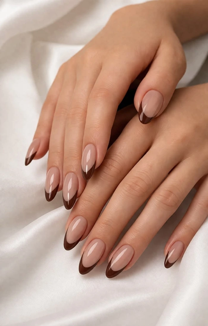 Chocolate brown French tip nails with a creamy nude base. Chocolate brown French tip nails with a creamy nude base.