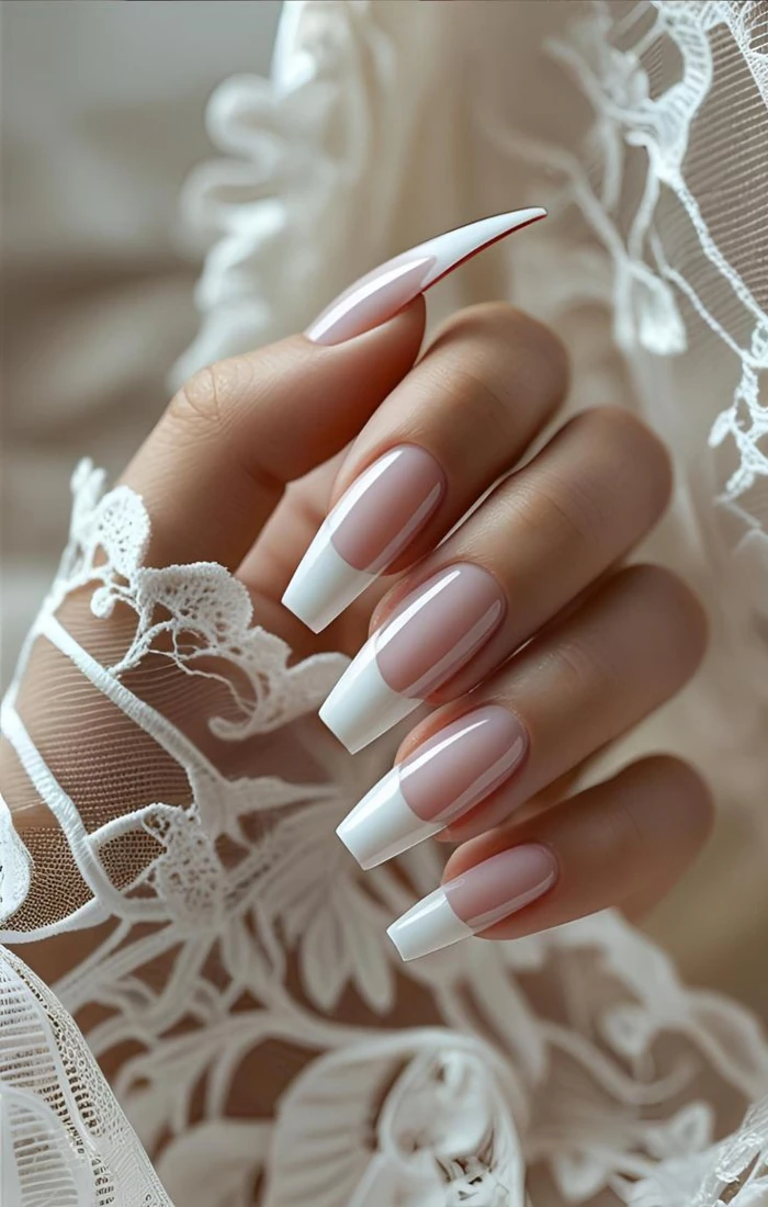 Classic French tip coffin nails with white tips and a sheer pink base Classic French tip coffin nails with white tips and a sheer pink base