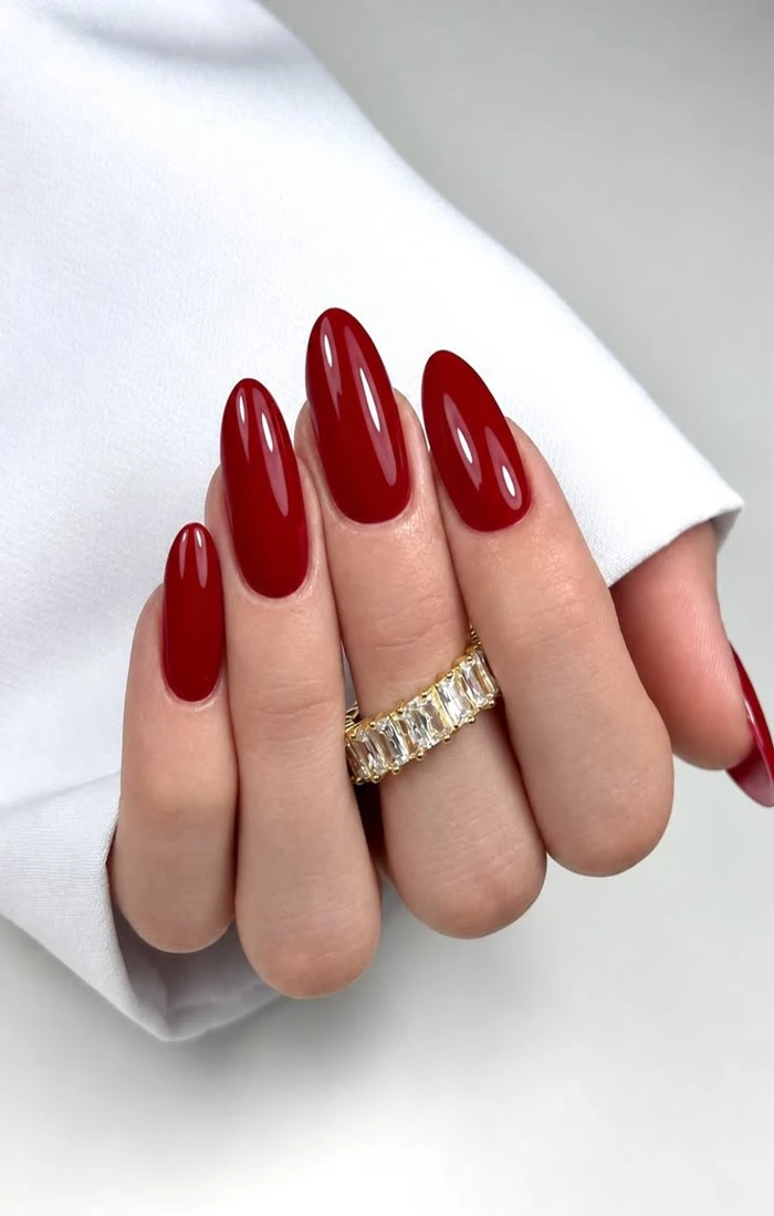 Classic glossy red Christmas nails on almond-shaped fingernails Classic glossy red Christmas nails on almond-shaped fingernails
