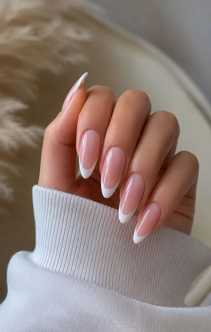 Classic white French tip nails with a sheer pink base and glossy finish. Classic white French tip nails with a sheer pink base and glossy finish.