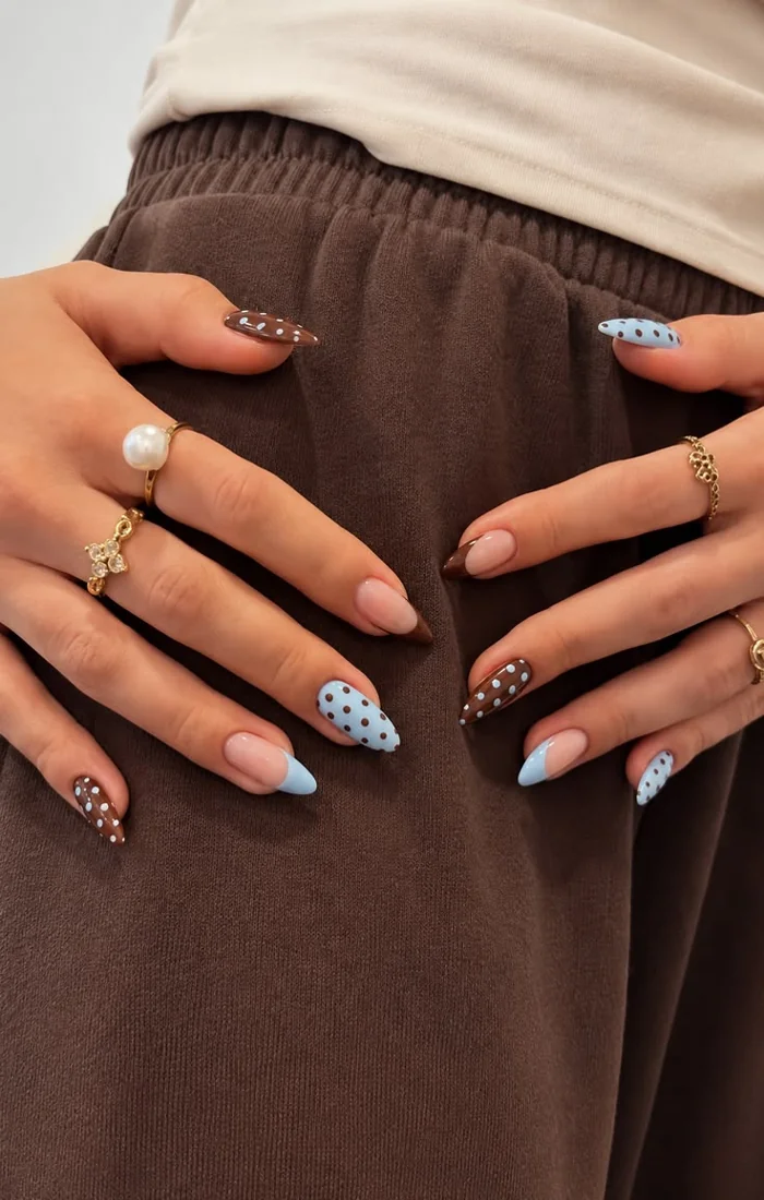 Colorful summer polka dot nails with small pink, yellow, and blue dots on a nude base. Colorful summer polka dot nails with small pink, yellow, and blue dots on a nude base.