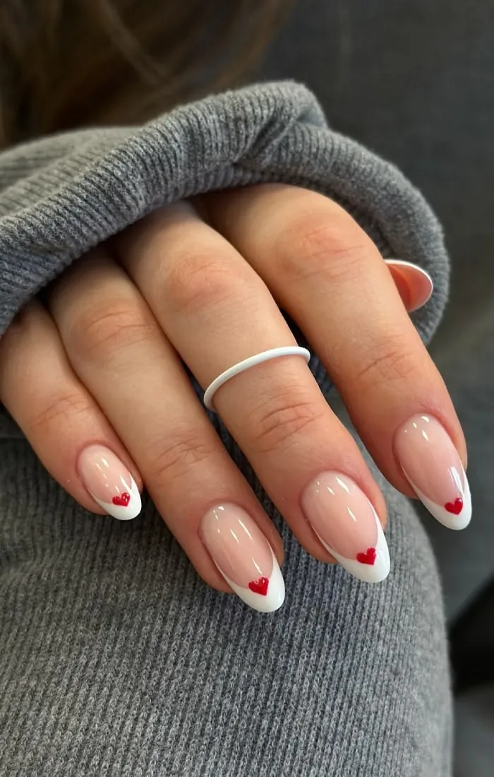 Cute pink French tip nails decorated with tiny heart accents. Cute pink French tip nails decorated with tiny heart accents.