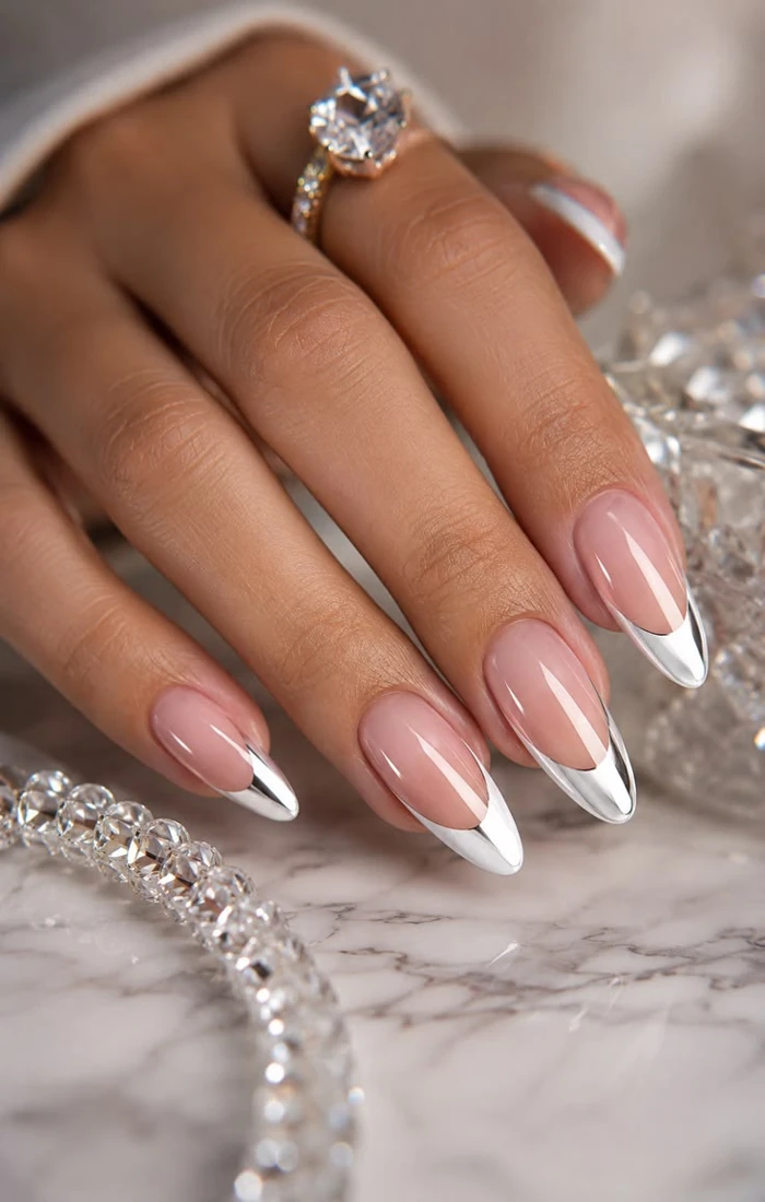 Nude almond nails with reflective silver chrome French tips Nude almond nails with reflective silver chrome French tips