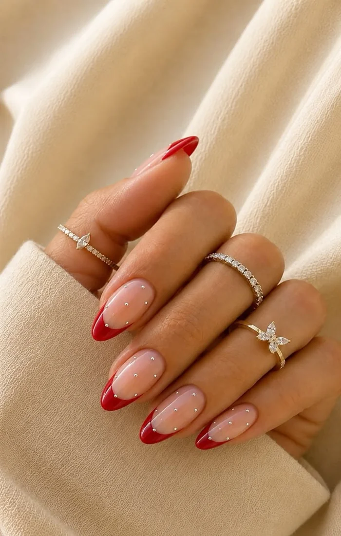Red French tip Christmas nails over a sheer nude base Red French tip Christmas nails over a sheer nude base